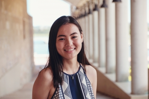 Happy Asian female young adult student in university - Australian Stock Image