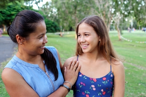 Happy Asian multicultural mother and daughter in the park - Australian Stock Image