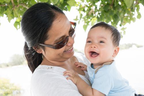 Happy Asian mum with her mixed race baby boy outside - Australian Stock Image