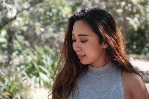 Happy Asian young adult woman in the park - Australian Stock Image
