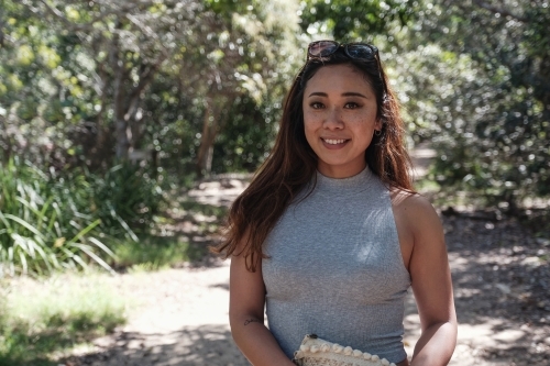 Happy Asian young adult woman in the park - Australian Stock Image