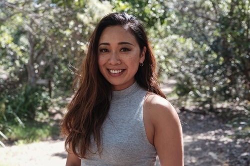 Happy Asian young adult woman in the park - Australian Stock Image