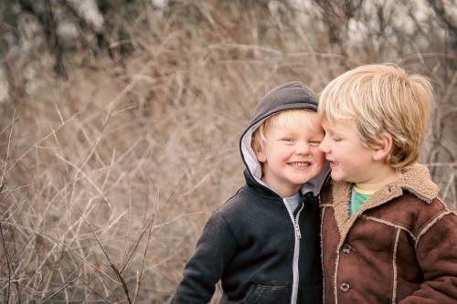 Happy brothers smiling together on outdoor adventure in winter - Australian Stock Image
