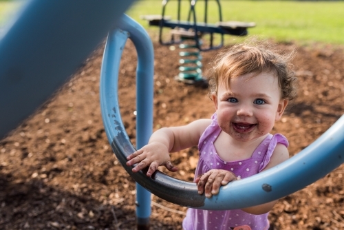Happy dirty kid playing at the park outdoors - Australian Stock Image