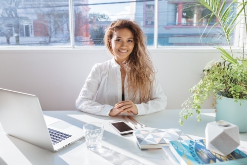 Happy employee posing for a business portrait at her desk