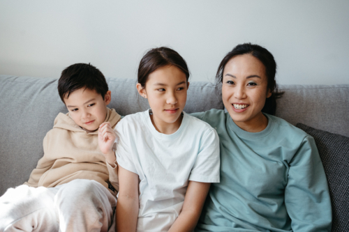 Happy family gathered and seated in the entertainment room. - Australian Stock Image