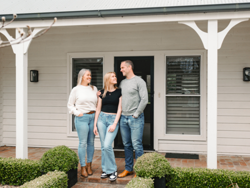 Happy family stands in the porch of their new home - Australian Stock Image