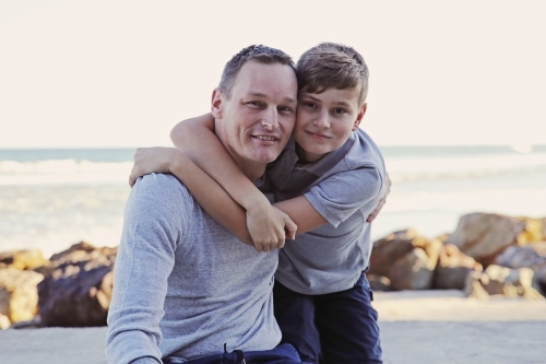 Happy father and teen son on the beach - Australian Stock Image