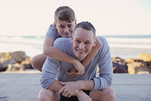 Happy father and teen son on the beach - Australian Stock Image