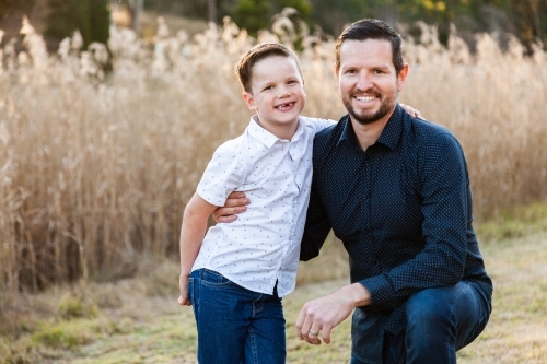 Happy father and young son portrait outside - Australian Stock Image