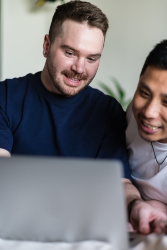 happy gay couple using computer - Australian Stock Image