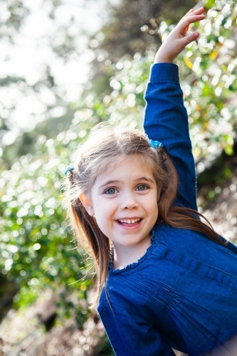 Happy girl playing outside in the garden - Australian Stock Image