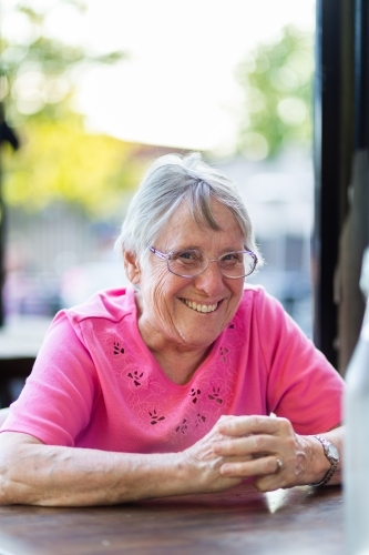 Happy grandmother sitting at a table smiling