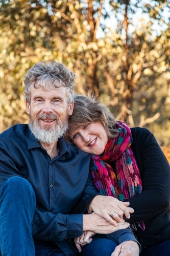Happy husband and wife sitting together outside