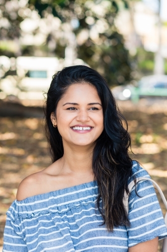 Happy Indian woman in a park - Australian Stock Image