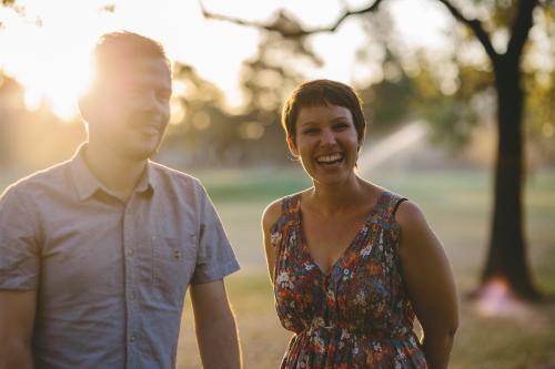 Happy laughing couple in park at sunset - Australian Stock Image