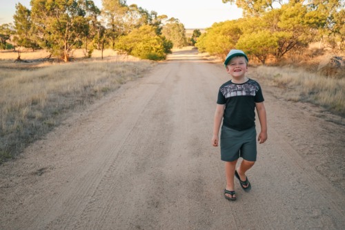 Happy little boy walking along bush track on Summer adventure - Australian Stock Image