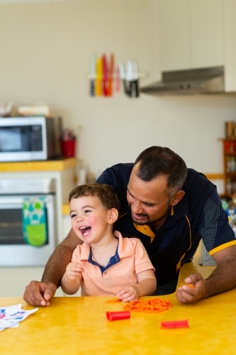happy little boy with his dad in the kitchen - Australian Stock Image