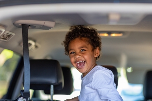 happy little kid in back of a van - Australian Stock Image