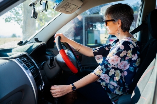 Happy middle aged driver in car with sunnies on - Australian Stock Image