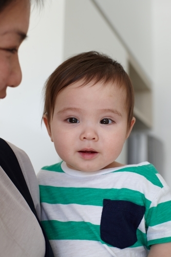 Happy mother holding baby boy in kitchen