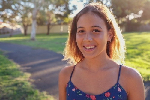 Happy multi ethnic teenage girl in the park - Australian Stock Image