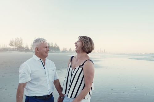 Happy multicultural senior couple on the beach - Australian Stock Image