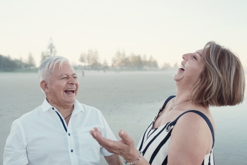 Happy multicultural senior couple on the beach - Australian Stock Image