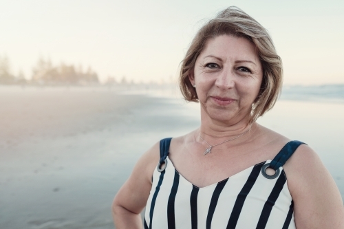 Happy multicultural senior woman on the beach - Australian Stock Image