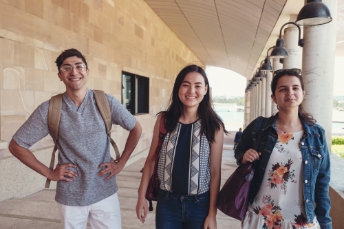 Happy multicultural students in library - Australian Stock Image