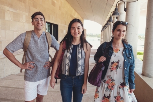 Happy multicultural students in library - Australian Stock Image