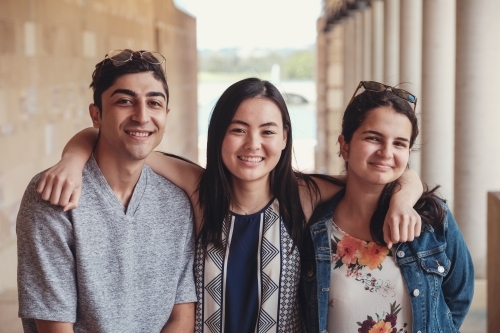 Happy multicultural students in library - Australian Stock Image