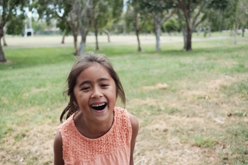Happy multicultural young girl at park - Australian Stock Image