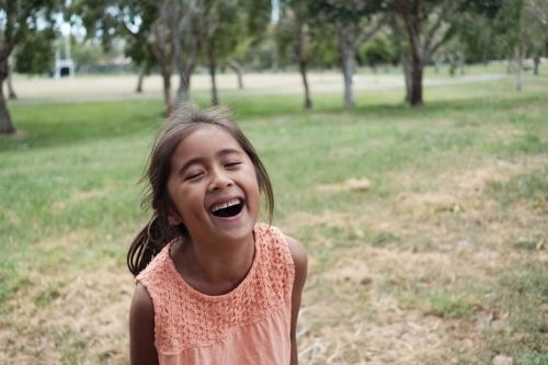 Happy multicultural young girl at park - Australian Stock Image
