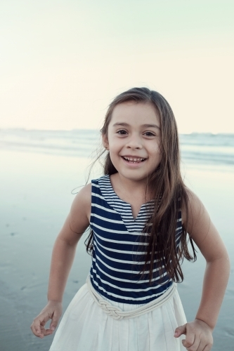 Happy multicultural young little girl on the beach - Australian Stock Image