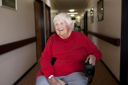 Happy nursing home resident sitting in wheelchair - Australian Stock Image