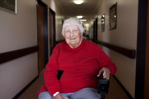 Happy nursing home resident sitting in wheelchair - Australian Stock Image