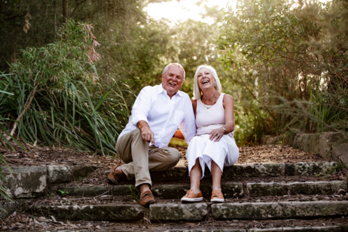 Happy senior couple sitting on a concrete staircase - Australian Stock Image