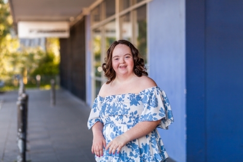 Happy smiling portrait of young lady with down syndrome outside shops - Australian Stock Image