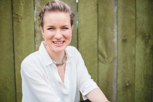 Happy smiling woman against fence - Australian Stock Image