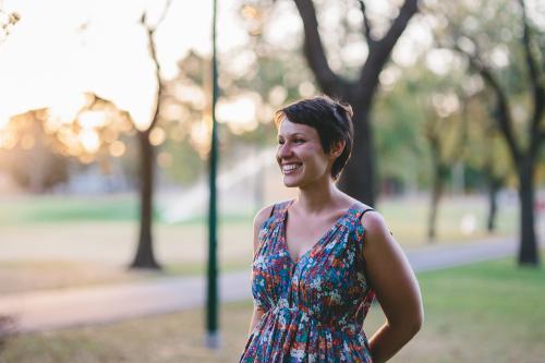 Happy smiling woman in summer dress at dusk - Australian Stock Image