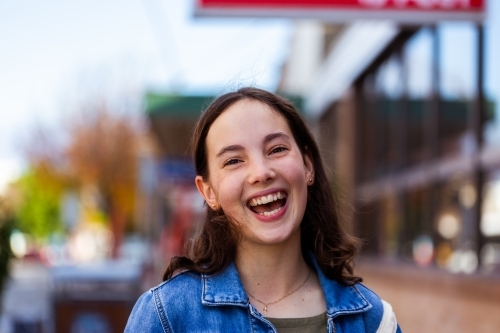 Happy teen girl laughing in urban area - Australian Stock Image