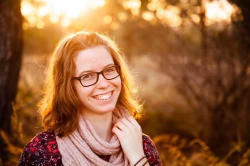 Happy teen girl smiling in golden sunset light outside - Australian Stock Image