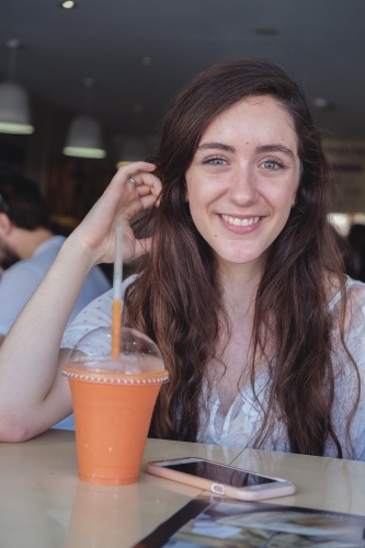 Happy teenage girl at juice bar - Australian Stock Image