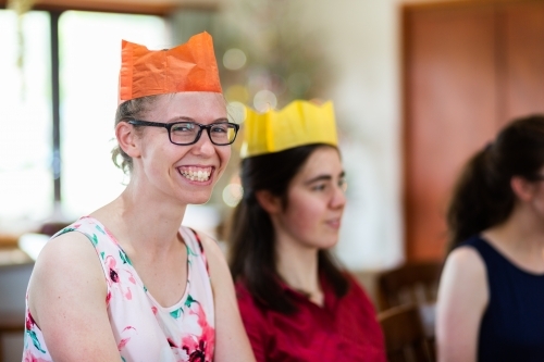 Happy teenage person wearing paper crown hat at Christmas time - Australian Stock Image