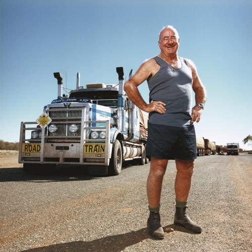 Happy truck driver standing front of road train - Australian Stock Image
