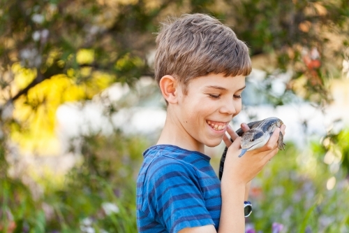 Happy twelve year old Aussie boy with pet blue tongue lizard - Australian Stock Image