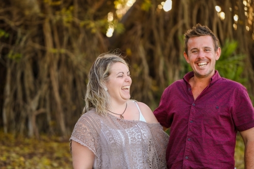 Happy twenty-something couple in golden afternoon light at the park - Australian Stock Image