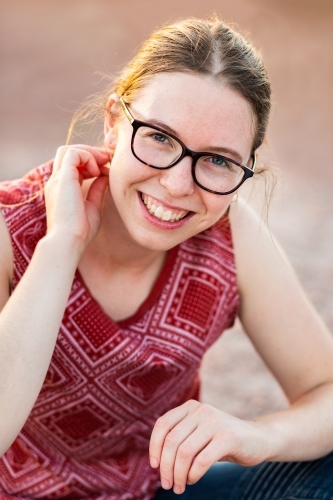 Happy young adult with glasses smiling outside - youth portrait - Australian Stock Image