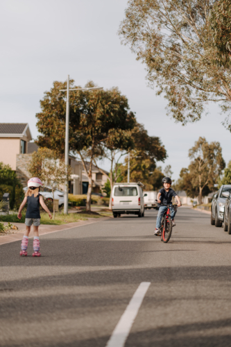 Happy young boy riding his bicycle on the street. - Australian Stock Image